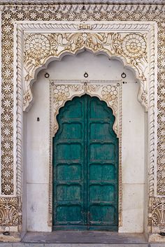 an ornately decorated doorway with green doors