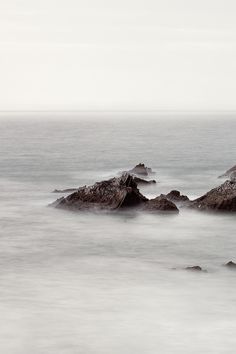 some rocks in the water and one is alone