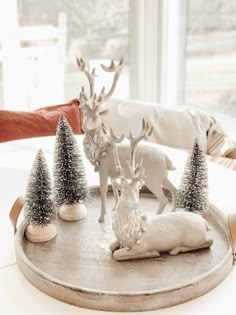 a tray that has some christmas decorations on it and two deer figurines in the middle