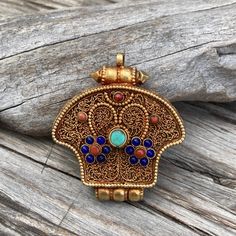 Handmade Tibetan prayer box or amulet pendant container traditionally used by Tibetan Buddhists as a reliquary to hold and carry sacred objects along with other holy objects or blessed items. Pendant made with filigree motif design and bezel setting. Size approx. 2" x 1.75" x 0.4" Material. copper with gold plated, lapis and coral beads. Sacred Objects, Prayer Box, Tibetan Buddhist, Lucky Charms, Motif Design, Amulets, Coral Beads, Lucky Charm, Bezel Setting