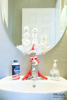 an elf is sitting on the sink in front of a mirror with soap and toothpaste