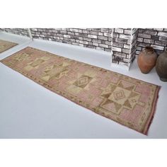 two rugs sitting on the floor next to vases and brick wall behind them