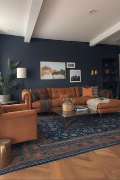 a living room filled with furniture and a large rug on top of a hard wood floor