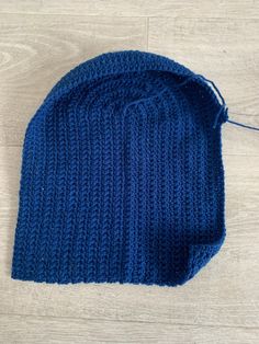 a blue knitted hat laying on top of a wooden floor