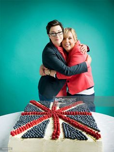 two people hugging each other in front of a cake with the british flag on it