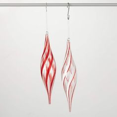 two red and white ornaments hanging from a wire