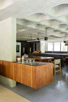 an open kitchen and dining room area in a modern style house with concrete flooring