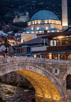 a stone bridge over a river next to buildings