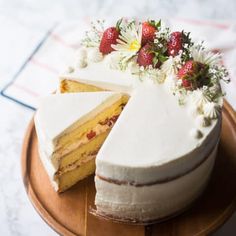 a cake that is sitting on top of a wooden platter with one slice cut out