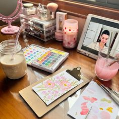 a table topped with lots of crafting supplies on top of a wooden table next to a laptop computer