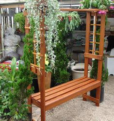 a wooden bench surrounded by potted plants