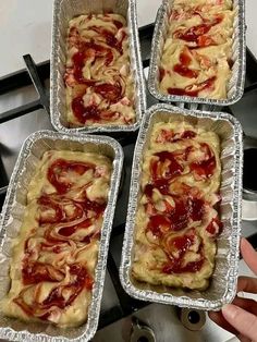 four pans filled with food sitting on top of a stove