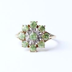 This enchanting 9ct gold ring features a vibrant green zircon at its heart, radiating a natural beauty that captivates the eye. The central zircon is surrounded by a further eight Zircon petals elegantly laid out in a striking star design , giving the ring a bold and sophisticated look. The floral-celestial inspired design adds a touch of grace and femininity, while the shimmering green stone offers a striking contrast against the warm gold band. Perfect for adding a splash of colour to any outfit, this ring combines elegance with a unique, timeless charm. An exceptional piece for those who appreciate refined yet distinctive jewellery. This ring comes presented in a Milly's Marvels gift box. SIZE - US 8 3/4 / UK S (Sizeable) WEIGHT - 2.8grams ERA - Contemporary. HALLMARKS - 375, a lion dat Marvel Gifts, Star Design, A Lion, Vibrant Green, Flower Ring, Green Stone, Star Designs, Gold Band, Gold Bands