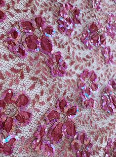 pink sequins and lace fabric with flowers on white background, closeup view