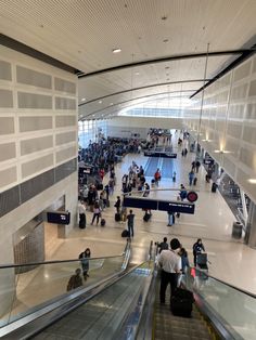 many people are walking up and down an escalator