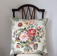 a pillow with flowers on it sitting on a chair