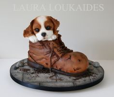 a cake made to look like a shoe with a puppy in it's boot