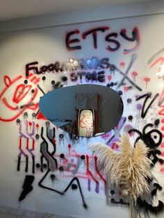 graffiti is on the wall next to a mirror