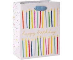 a birthday gift bag with candles on the front and happy birthday written on the side