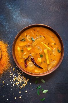 a bowl of soup with spices on the side