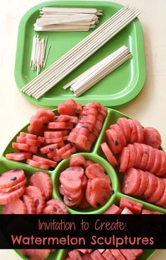 watermelon sculpturies are arranged on a green tray with chopsticks