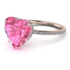 a pink heart shaped ring with diamonds on the sides and an inscription that reads, segel