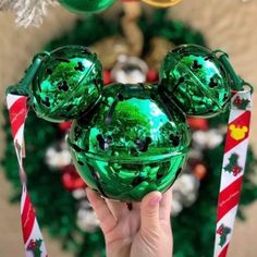 someone is holding up a mickey mouse ornament