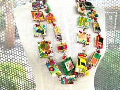 Double strand of small RUBBER squares with individual mini collages- both sides of the squares show mini collages.  This necklace is all rubber squares-making the necklace full of individual collages. Colorful and light weight. A fascinating piece of jewelry- all artist made-certainly original.A real LOOK AT ME-original -necklace -  artist made. This Artist's favorite Funky Necklaces, Diy Jewelry Recycled, Upcycling Jewelry, Collage Necklace, Upcycled Sewing, Jewelry Assemblage, Fabric Necklaces, Scarf Diy, Collage Jewelry