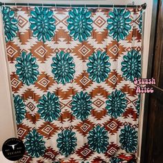 the shower curtain is decorated with blue and brown flowers on it's side, along with an orange and white geometric design