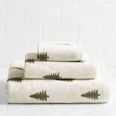 three white towels with green trees on them