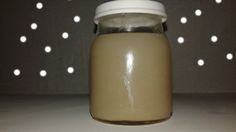 a glass jar filled with liquid sitting on top of a white counter next to a wall