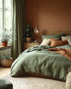 a bed with green linens and pillows in a bedroom next to a large window