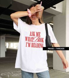 a woman wearing a white t - shirt with the words ask me what's book i'm reading