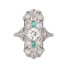 "Finely detailed vintage Art Deco emerald & diamond ring (circa 1920s to 1930s) crafted in platinum.  Center set old European cut diamond is estimated at .90 carats, accented with 12 estimated 0.05 carat old mine cut diamonds. The total diamond weight is estimated at 1.50 carats (estimated at I-J color and VS2-SI2 clarity). Two emeralds total an estimated 0.10 carats. The emeralds are in good condition with a few nicks evident and general wear visible under a 10x loupe.   The elongated mount wit Art Deco Emerald Diamond Ring With Accents, Art Deco Emerald Ring With Center Stone, Vintage Green Diamond Platinum Ring, Vintage Green Diamond Ring In Platinum, Vintage Emerald Ring With Diamond Accents, Heirloom Platinum Emerald Ring With 17 Jewels, Antique Emerald Diamond Ring With Brilliant Cut, Heirloom Emerald Ring With 17 Jewels In Platinum, Art Deco Emerald Ring With Platinum