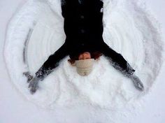 a person laying down in the snow with their legs spread out and hands extended over them