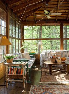 a living room filled with lots of furniture next to a window covered in wood planks