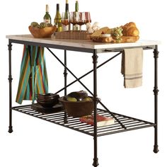 a kitchen island with wine bottles, bread and other food items on the counter top