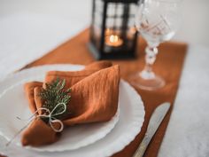 a place setting with an orange napkin and silverware