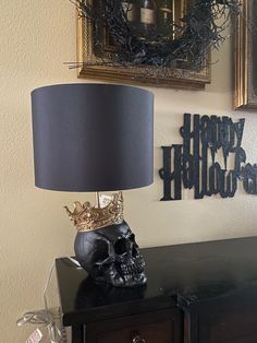 a skull lamp sitting on top of a black table next to a framed sign and mirror