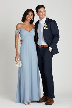 a man and woman in formal wear standing next to each other smiling at the camera