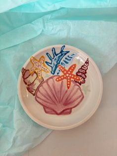 a plate with colorful designs on it sitting on top of a blue sheet of paper