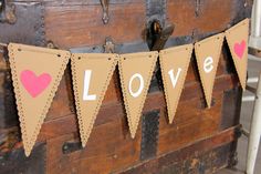 an old trunk with some paper bunting on it that says love hanging from the top