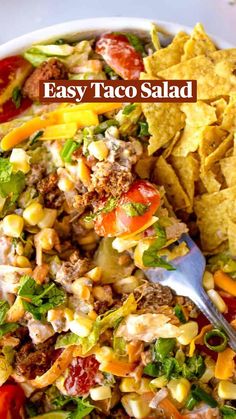 a white bowl filled with taco salad and tortilla chips on the side