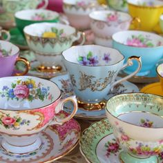 a table topped with lots of colorful cups and saucers on top of each other