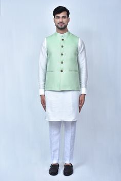 Light green bundi in with geometric patterns. Comes with off white kurta and pant.
Components: 3
Pattern: Woven
Type Of Work: Geometric Patterns
Neckline: Mandarin Collar
Sleeve Type: Bundi: Sleeveless, Kurta: Cuff Sleeves
Fabric: Kurta and Pant: Art Silk, Bundi: Art Silk Jacquard
Color: Green, Off White
Other Details: 
Front carved button bundi
Welt pocketed bundi
Elasticated pant waistband
Occasion: Wedding - Aza Fashions Fitted Green Chanderi Bandhgala, Fitted Green Bandhgala In Chanderi, Green Chanderi Bandhgala With Dabka Work, Green Chanderi Bandhgala With Dabka Details, Green Dabka Chanderi Bandhgala, White Cotton Silk Nehru Jacket For Eid, White Cotton Silk Nehru Jacket For Festivals, Pista Green Cotton Kurta For Transitional Season, Designer Green Cotton Sherwani