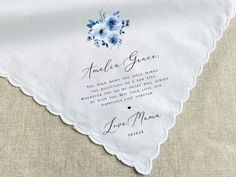 a white handkerchief with blue flowers on it and the words amelie grace written in cursive writing