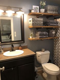 a bathroom with shelving above the toilet