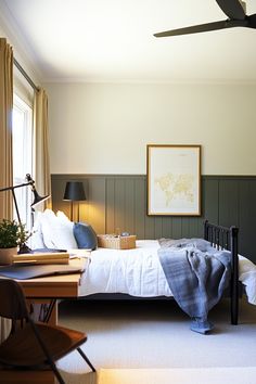 a bed sitting in a bedroom next to a window with a fan on top of it