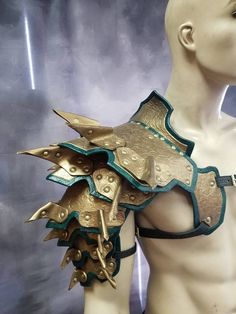 a male mannequin with gold and green armor on it's chest is shown