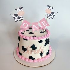 a pink and black cake with two giraffes on it's top